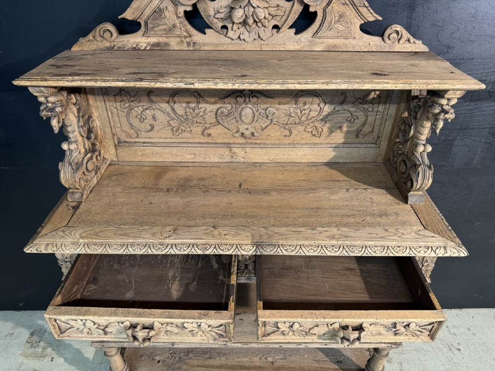 A 19th-century French carved oak buffet featuring an ornate crest, open shelf, turned columns, and carved drawers. View VII
