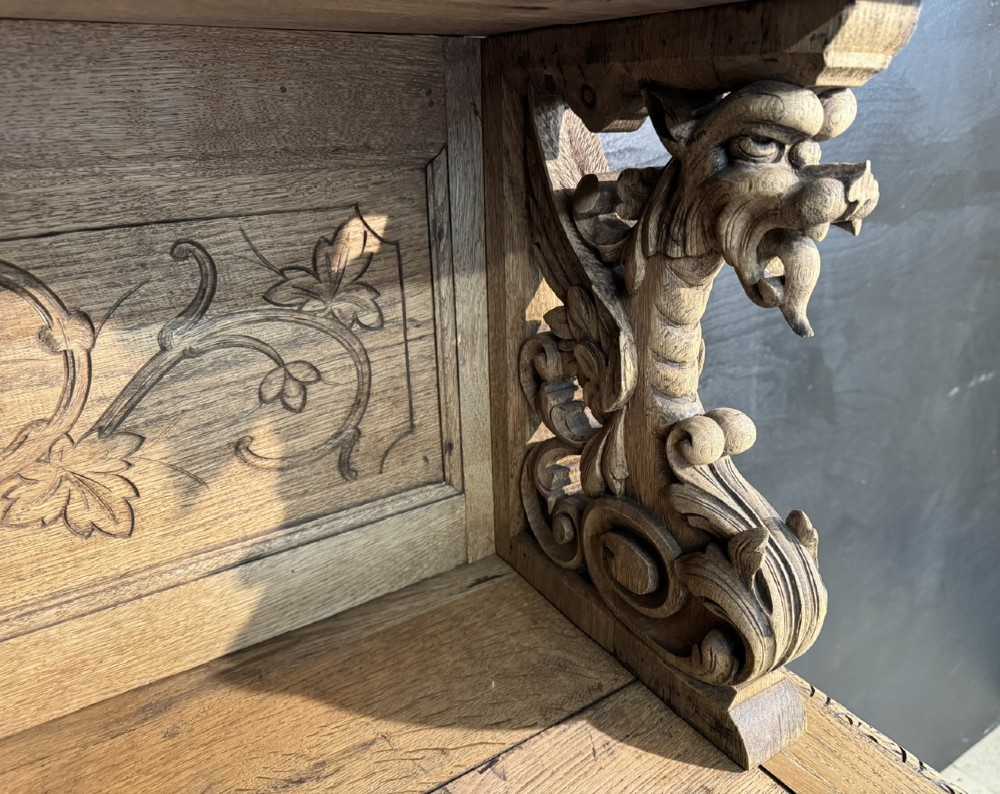 A 19th-century French carved oak buffet featuring an ornate crest, open shelf, turned columns, and carved drawers. View IX