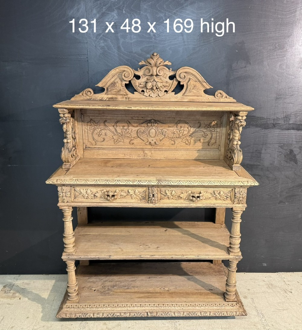 A 19th-century French carved oak buffet featuring an ornate crest, open shelf, turned columns, and carved drawers. View XV