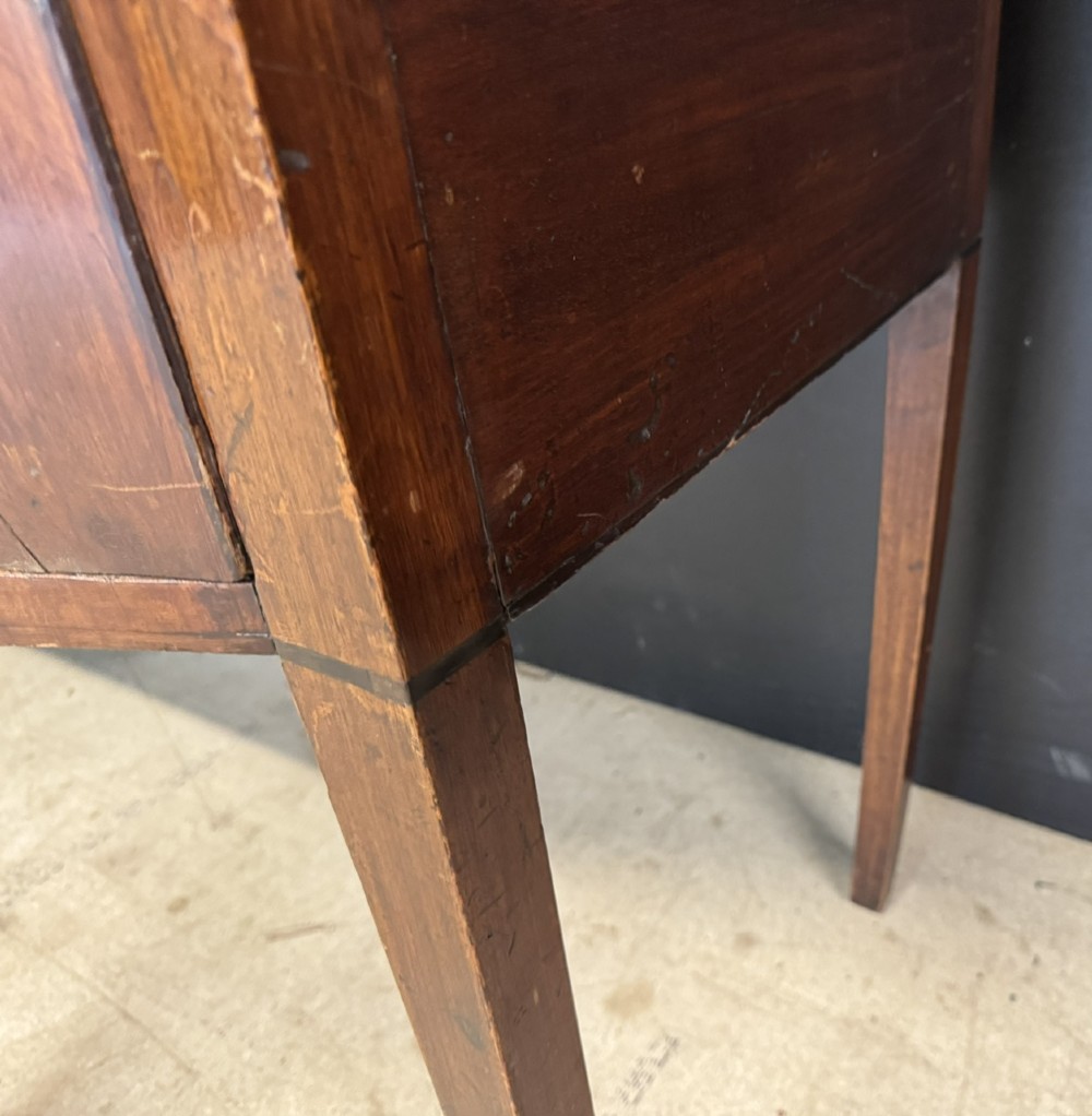An antique Georgian mahogany bow-front sideboard featuring a central drawer, flanking cupboard doors, brass lion mask ring handles, and square tapered legs. View VII