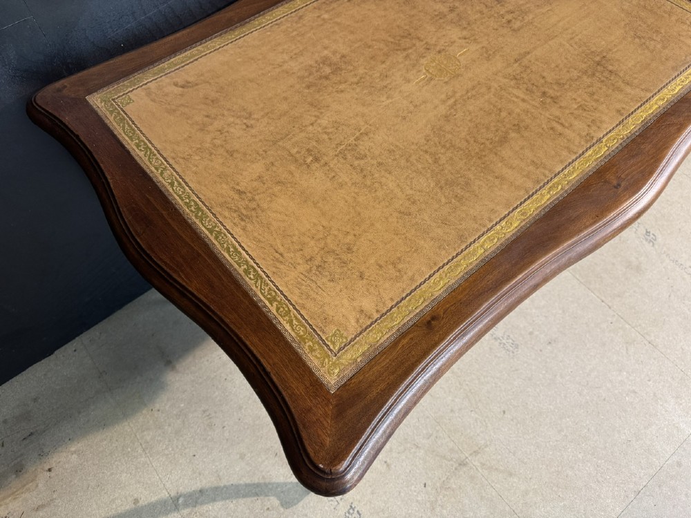 A French Rococo style writing desk crafted from carved light brown wood with a tan leather top, cabriole legs, and a carved drawer front. View XI