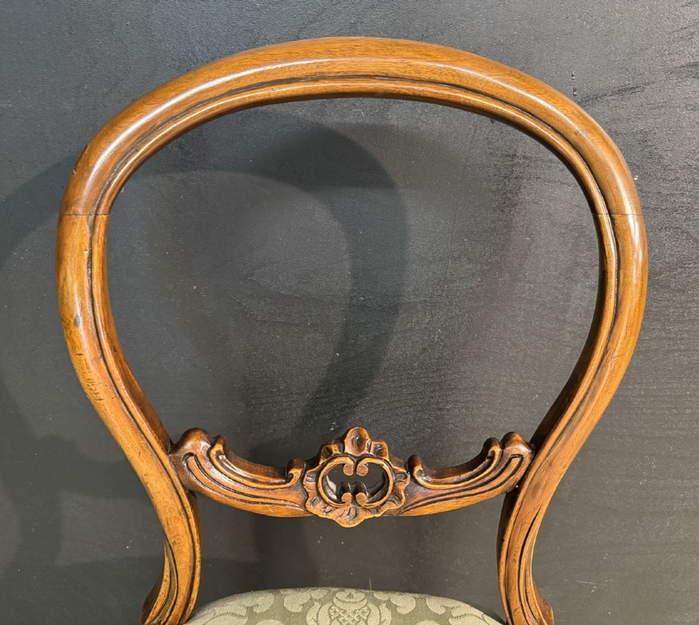 A Victorian balloon back side chair featuring a carved warm brown wood frame, cabriole front legs, and a sage green damask upholstered seat. View II