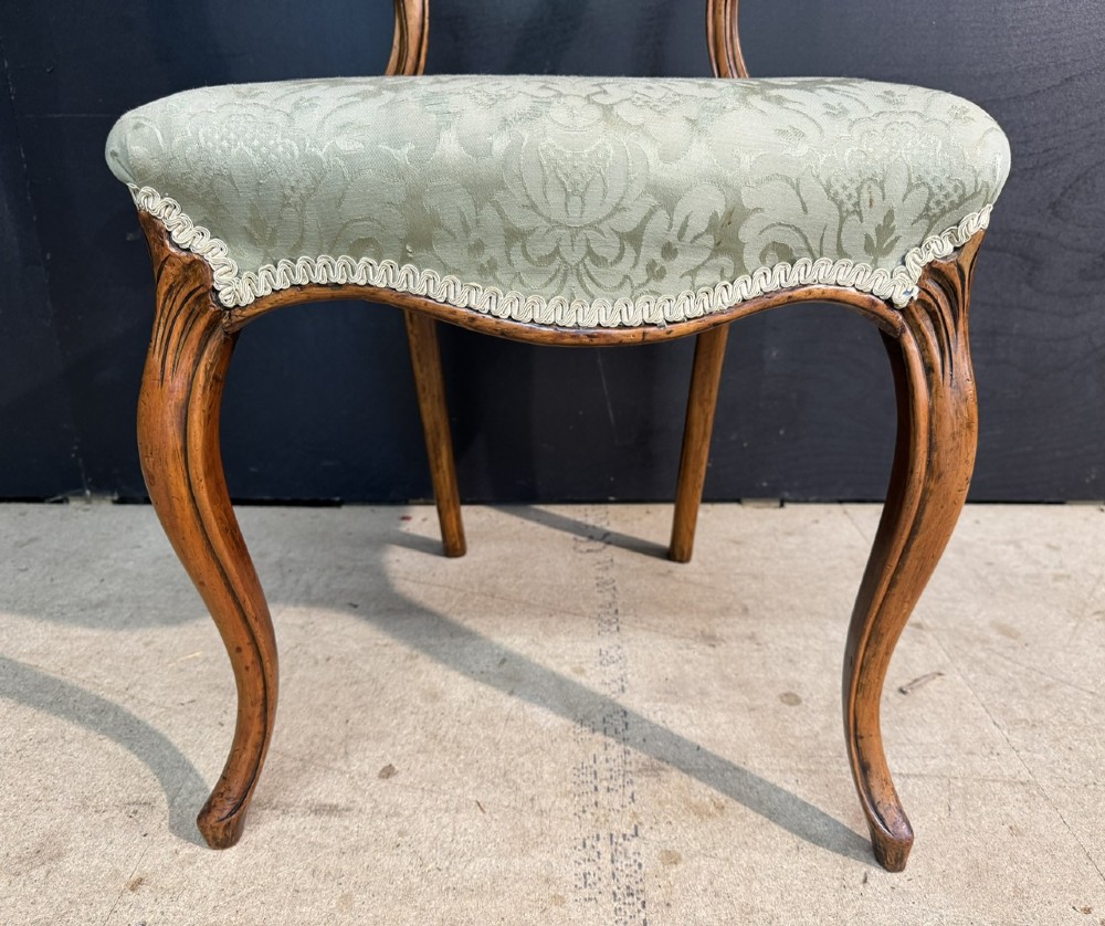 A Victorian balloon back side chair featuring a carved warm brown wood frame, cabriole front legs, and a sage green damask upholstered seat. View IV
