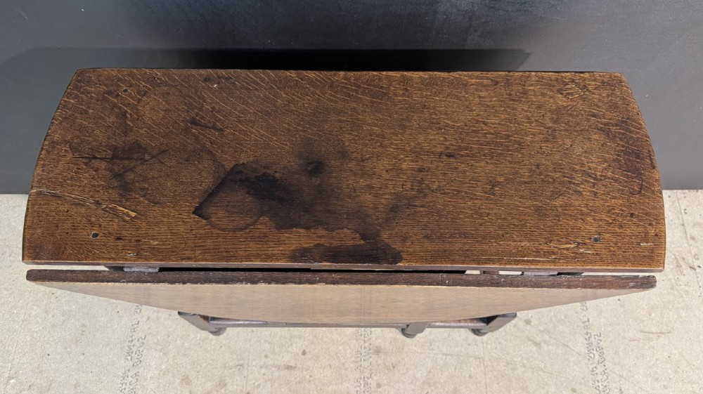 An eighteenth-century dark oak gateleg table featuring an oval drop-leaf top supported by turned legs and stretchers. View III