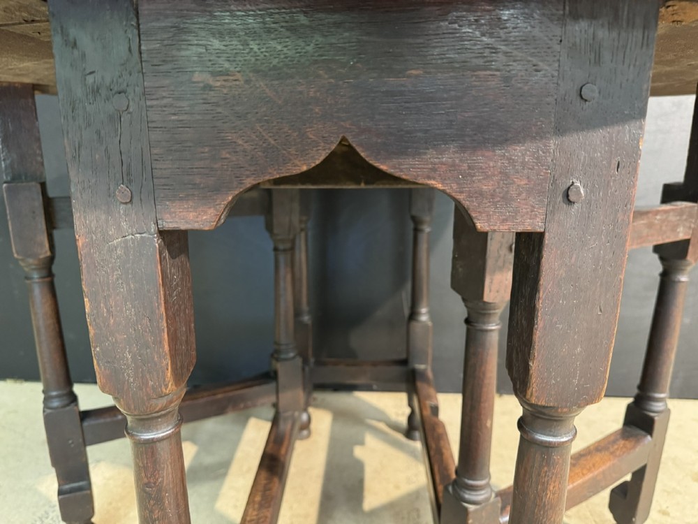 An eighteenth-century dark oak gateleg table featuring an oval drop-leaf top supported by turned legs and stretchers. View VIII