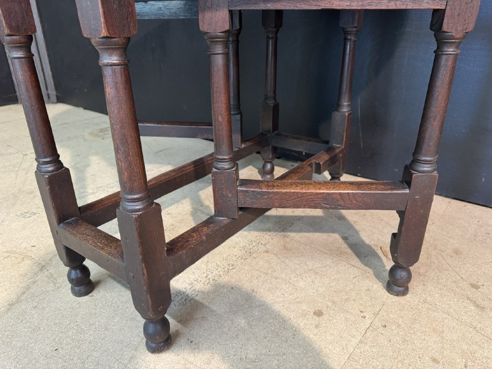 An eighteenth-century dark oak gateleg table featuring an oval drop-leaf top supported by turned legs and stretchers. View IX