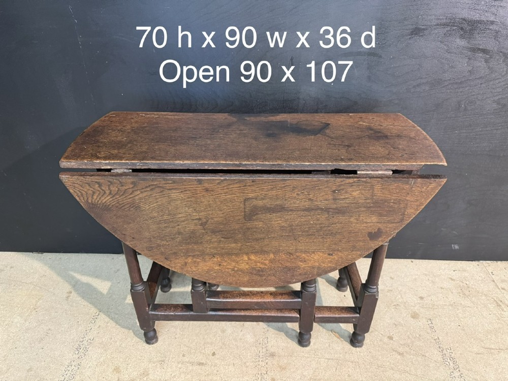 An eighteenth-century dark oak gateleg table featuring an oval drop-leaf top supported by turned legs and stretchers. View XII