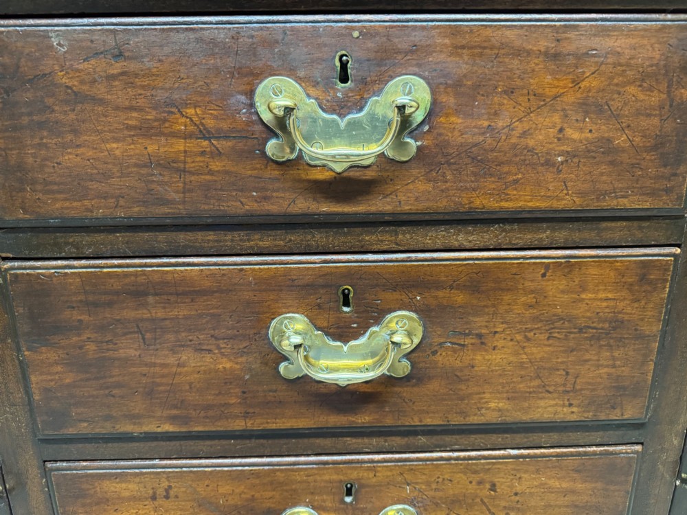 A dark oak Welsh dresser featuring a three-tier open plate rack canopy atop a base with four central drawers flanked by two panelled cupboard doors with brass handles. View X