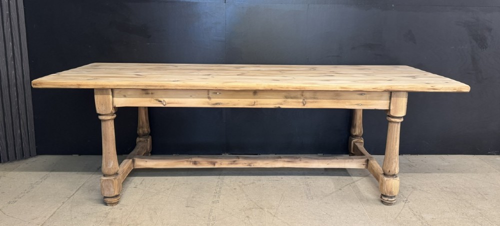 A large antique natural pine dining table featuring turned legs connected by a low H-stretcher and a solid plank top. View II