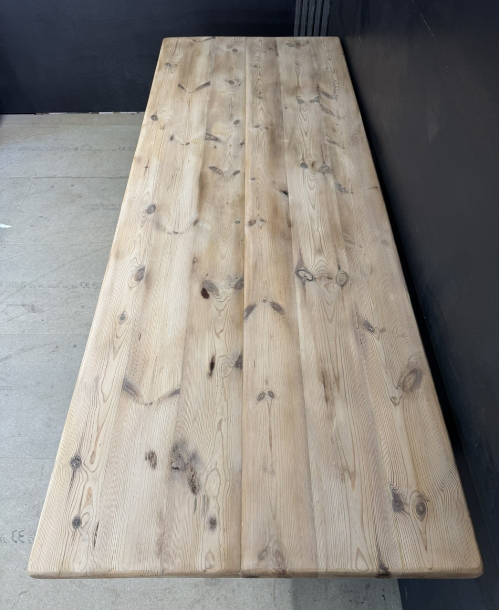 A large antique natural pine dining table featuring turned legs connected by a low H-stretcher and a solid plank top. View VII