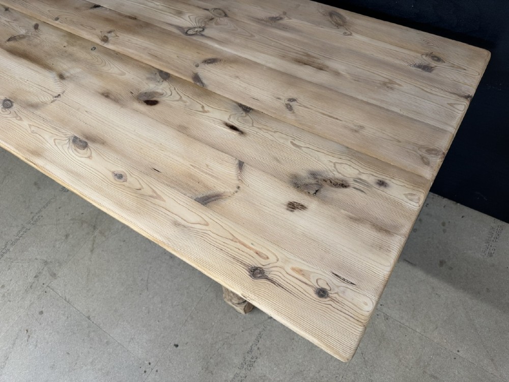 A large antique natural pine dining table featuring turned legs connected by a low H-stretcher and a solid plank top. View VIII
