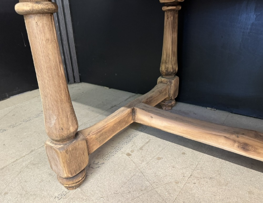 A large antique natural pine dining table featuring turned legs connected by a low H-stretcher and a solid plank top. View XIII