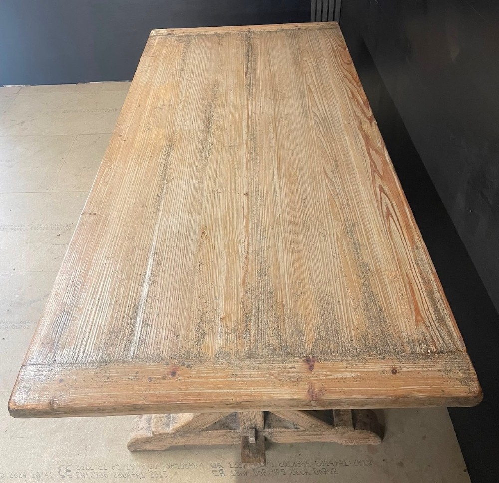 A large, pale pine farmhouse dining table featuring a solid timber top and a sturdy trestle-style base with diagonal bracing. View XIII