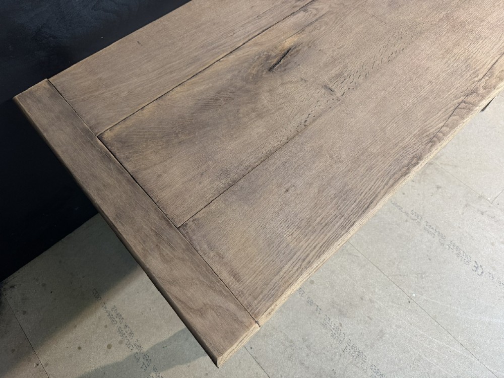 A rectangular bleached oak farmhouse dining table with turned legs, breadboard ends, and a low central stretcher base. View VII