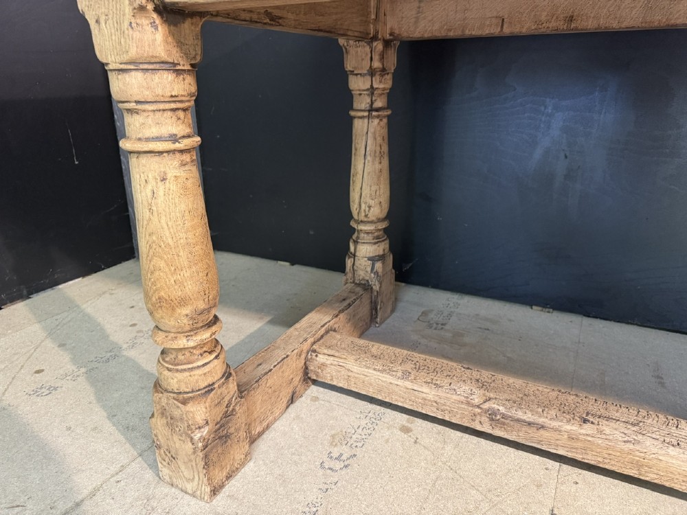 A rectangular bleached oak farmhouse dining table with turned legs, breadboard ends, and a low central stretcher base. View VIII