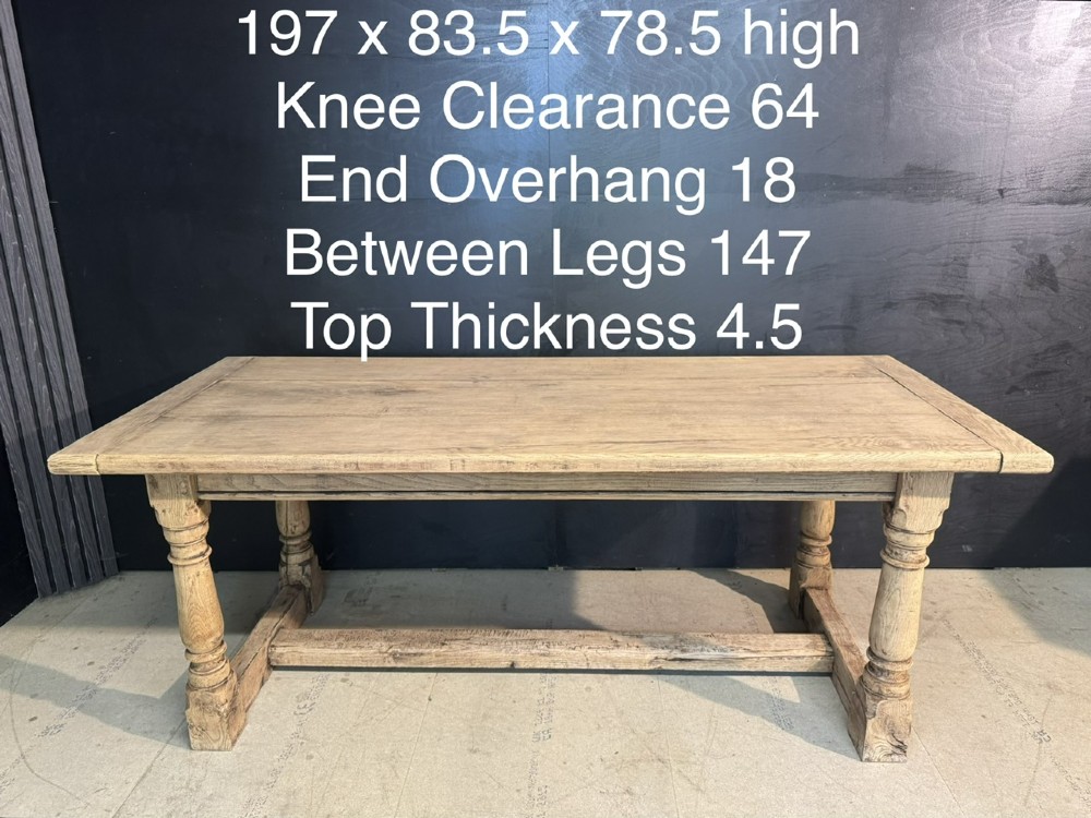 A rectangular bleached oak farmhouse dining table with turned legs, breadboard ends, and a low central stretcher base. View XIV