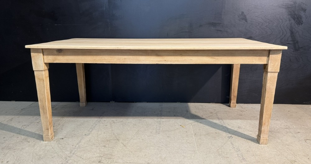 A rectangular light oak dining table featuring clean straight edges, a planked top, and simple tapered legs against a neutral background. View II