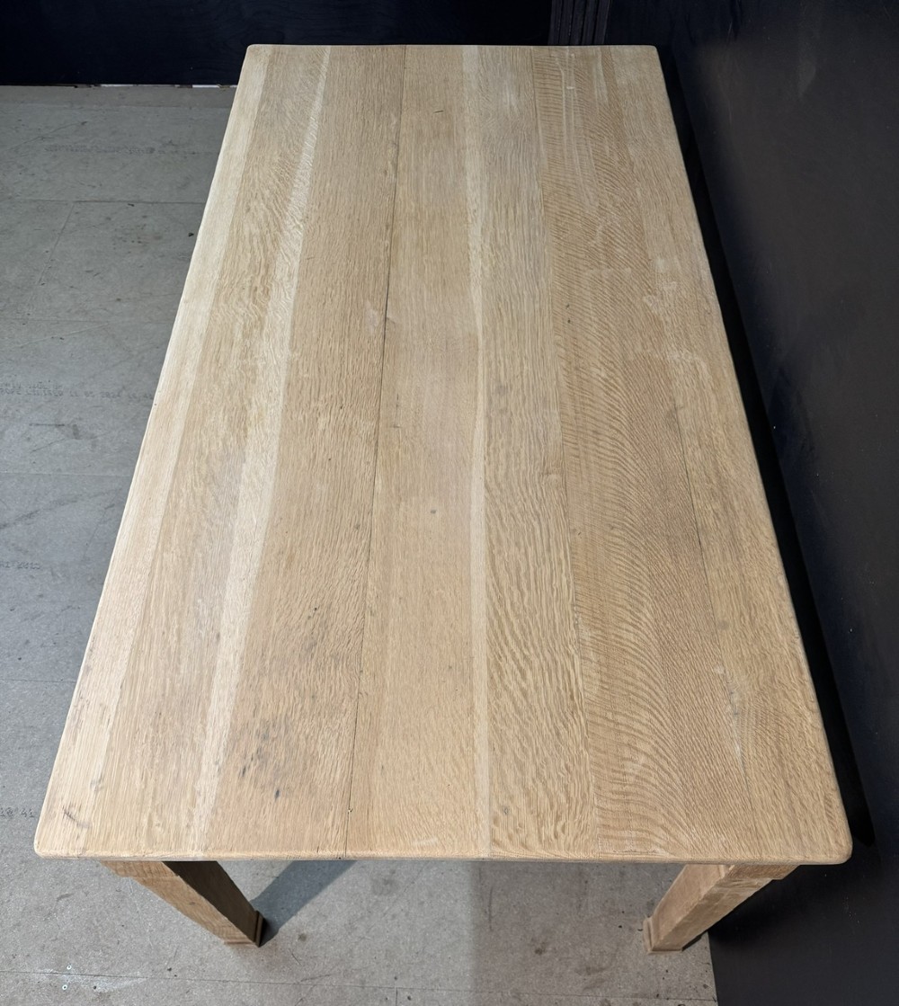 A rectangular light oak dining table featuring clean straight edges, a planked top, and simple tapered legs against a neutral background. View V