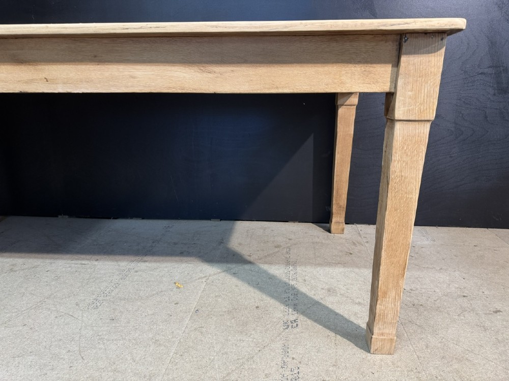 A rectangular light oak dining table featuring clean straight edges, a planked top, and simple tapered legs against a neutral background. View VII