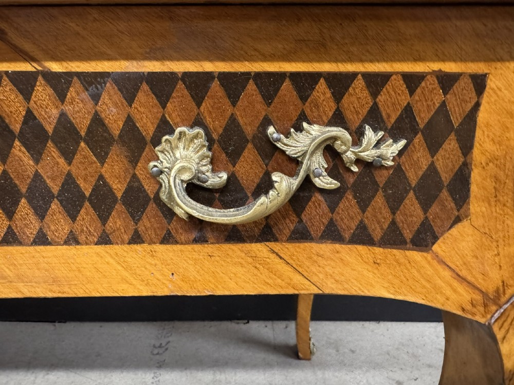 A French Louis XV style marquetry bureau plat featuring floral inlaid wood on the top surface, a diamond parquetry drawer frieze, gilt-bronze corner mounts, and curved cabriole legs. View VIII