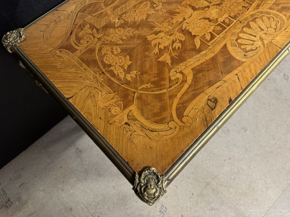 A French Louis XV style marquetry bureau plat featuring floral inlaid wood on the top surface, a diamond parquetry drawer frieze, gilt-bronze corner mounts, and curved cabriole legs. View IX