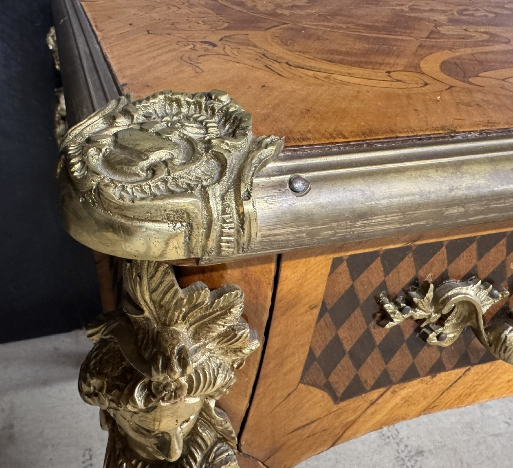 A French Louis XV style marquetry bureau plat featuring floral inlaid wood on the top surface, a diamond parquetry drawer frieze, gilt-bronze corner mounts, and curved cabriole legs. View XIII