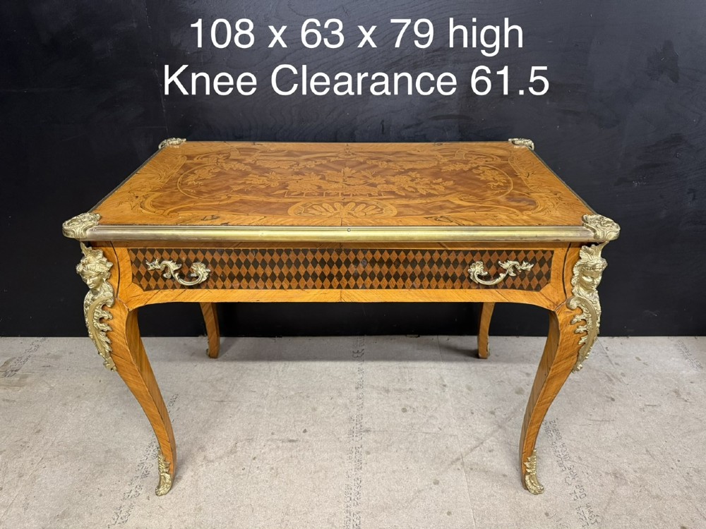 A French Louis XV style marquetry bureau plat featuring floral inlaid wood on the top surface, a diamond parquetry drawer frieze, gilt-bronze corner mounts, and curved cabriole legs. View XIV