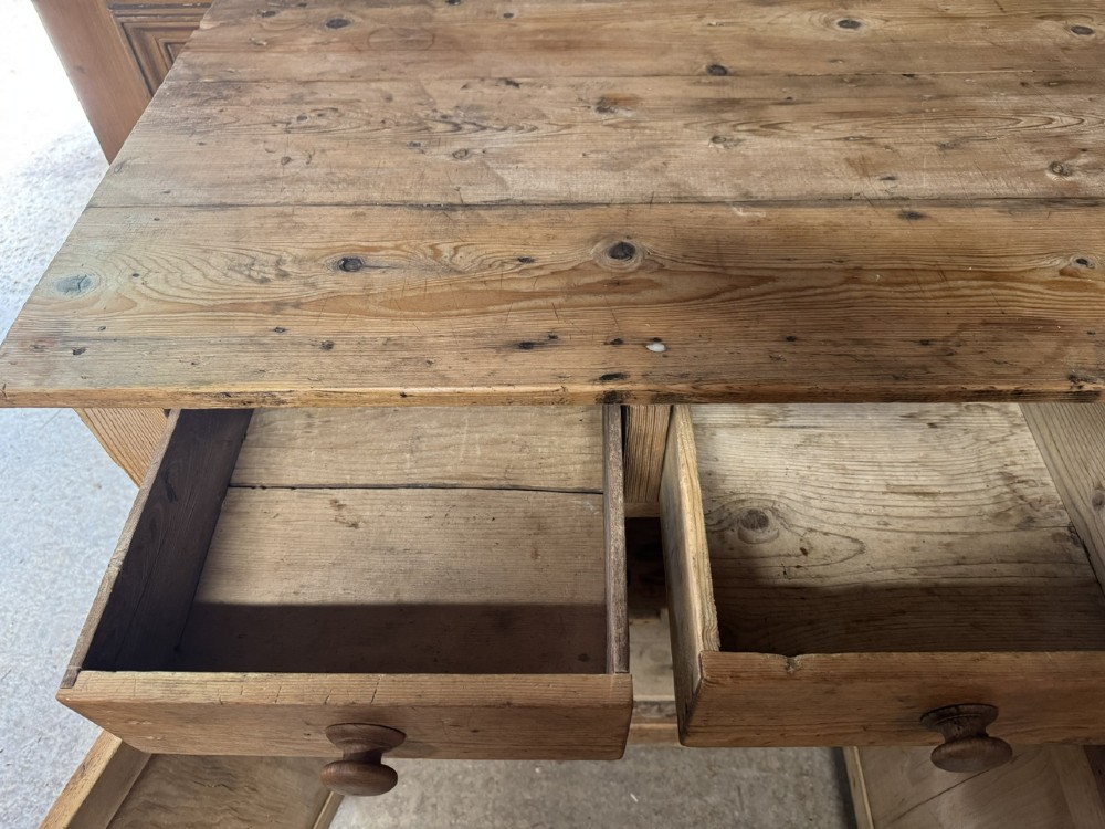 An antique country pine low cupboard featuring three top drawers over three panelled cupboard doors with turned wooden handles. View VIII