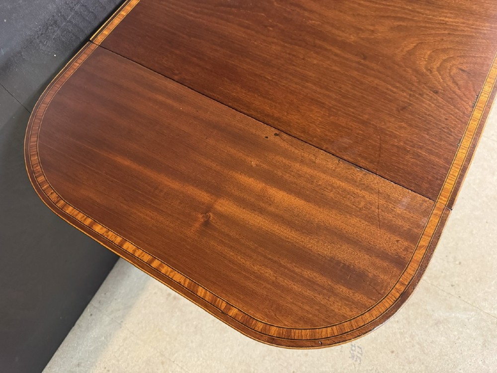 A Georgian mahogany sofa table featuring two inline drawers with satinwood string inlay, drop leaves, twin-pillar supports, and splayed legs ending in brass claw feet on castors. View XII