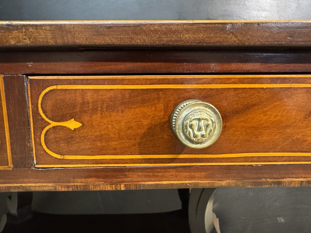 A Georgian mahogany sofa table featuring two inline drawers with satinwood string inlay, drop leaves, twin-pillar supports, and splayed legs ending in brass claw feet on castors. View XV