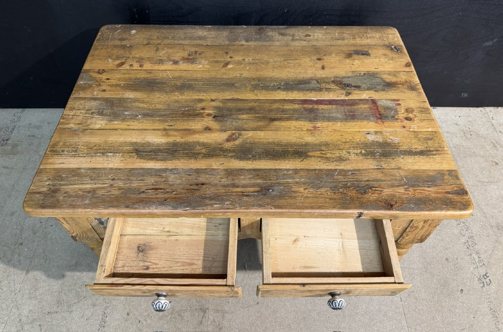 A rectangular rustic pine coffee table featuring a plank top, two front drawers with decorative ceramic knobs, and four turned wooden legs. View IV