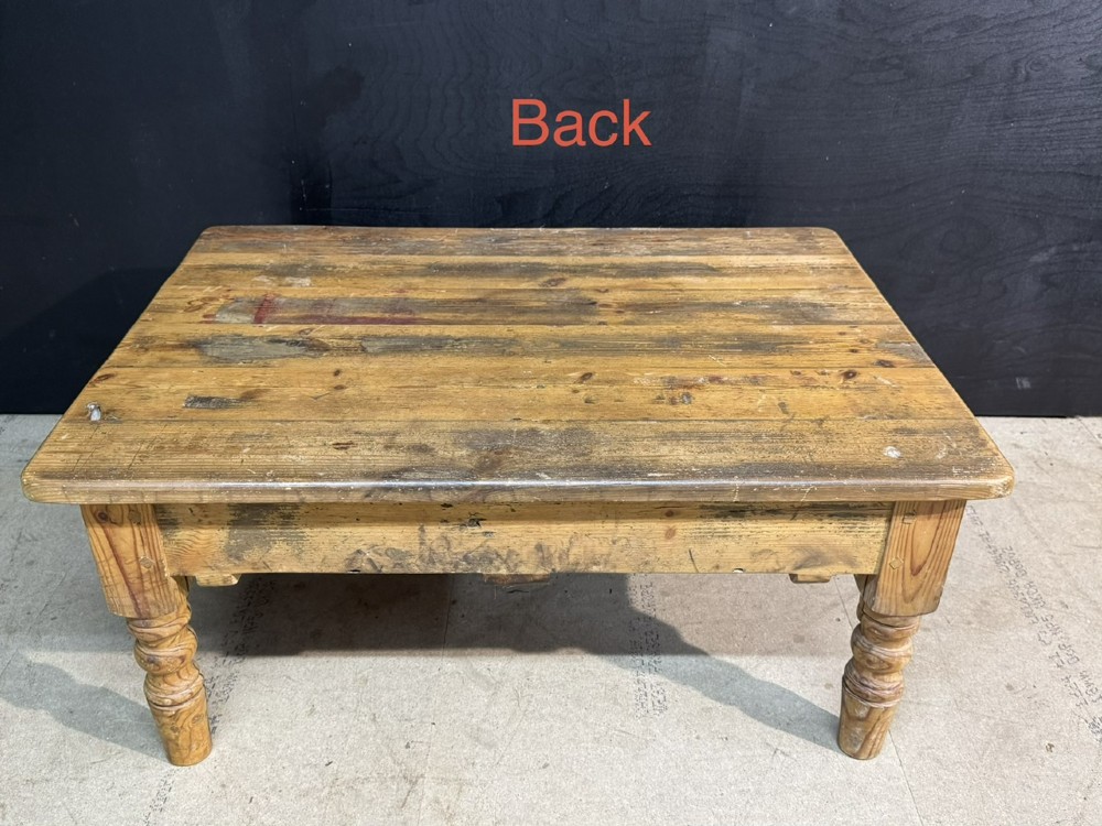 A rectangular rustic pine coffee table featuring a plank top, two front drawers with decorative ceramic knobs, and four turned wooden legs. View VII