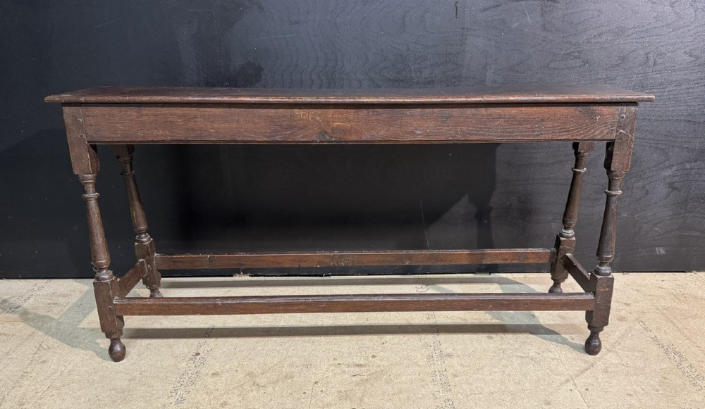A long dark oak Georgian joint stool with turned legs, a rectangular top, and lower wooden stretchers. View II