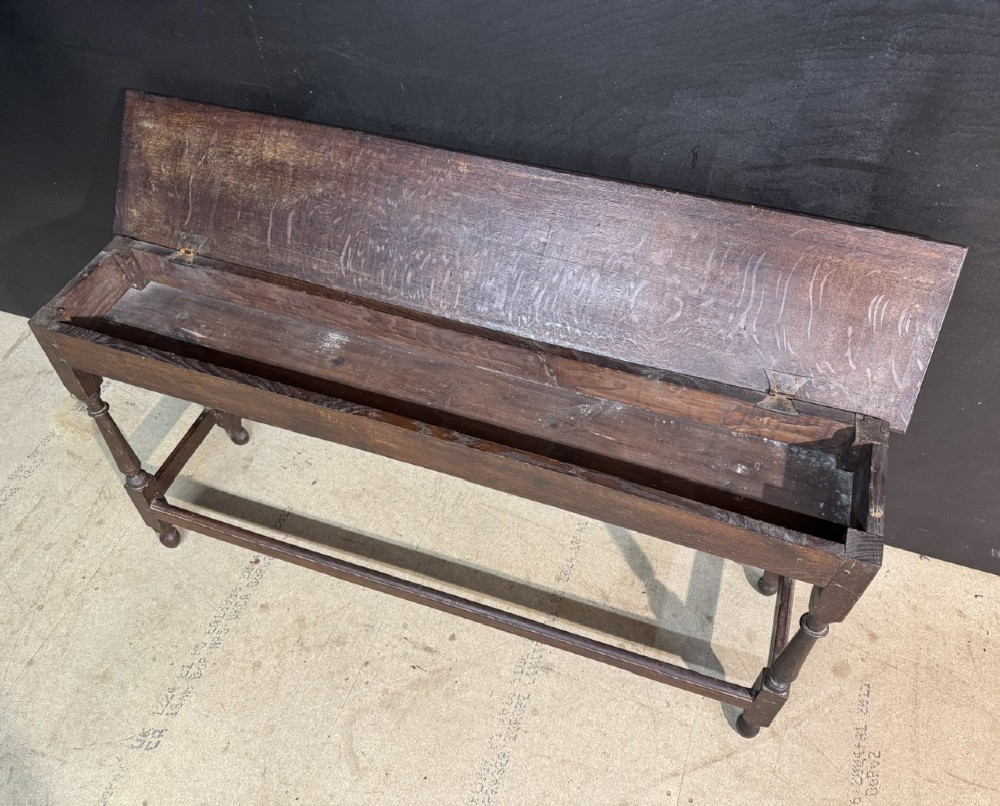 A long dark oak Georgian joint stool with turned legs, a rectangular top, and lower wooden stretchers. View IV