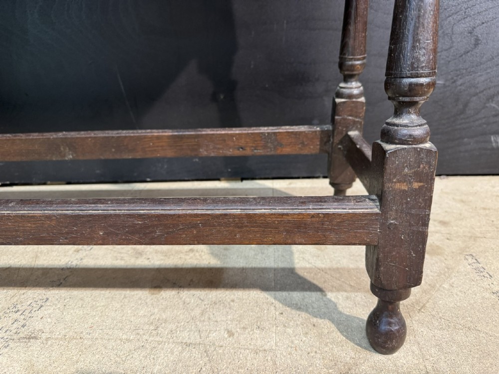 A long dark oak Georgian joint stool with turned legs, a rectangular top, and lower wooden stretchers. View IX
