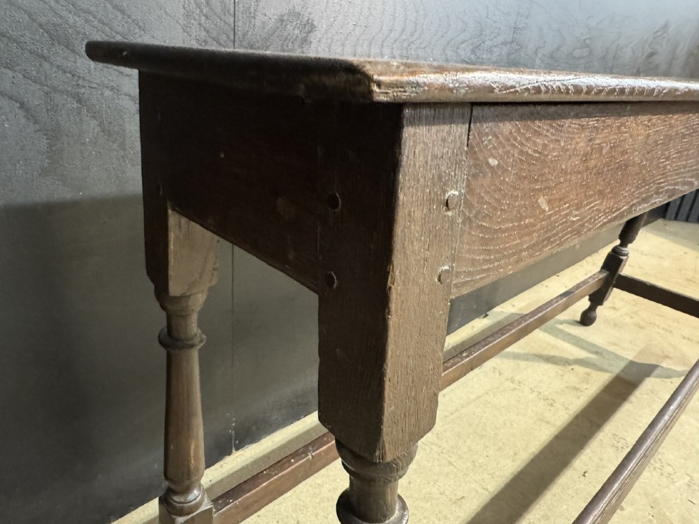 A long dark oak Georgian joint stool with turned legs, a rectangular top, and lower wooden stretchers. View XI