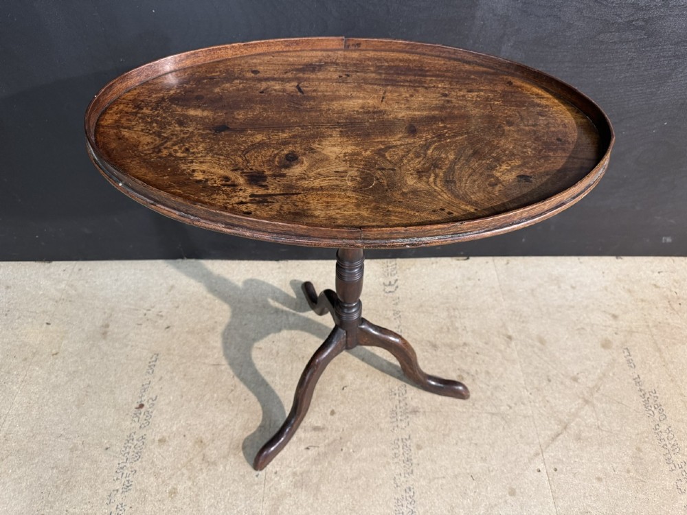 A Georgian mahogany tilt-top table featuring a circular top raised on a turned pedestal column and tripod cabriole legs. View II