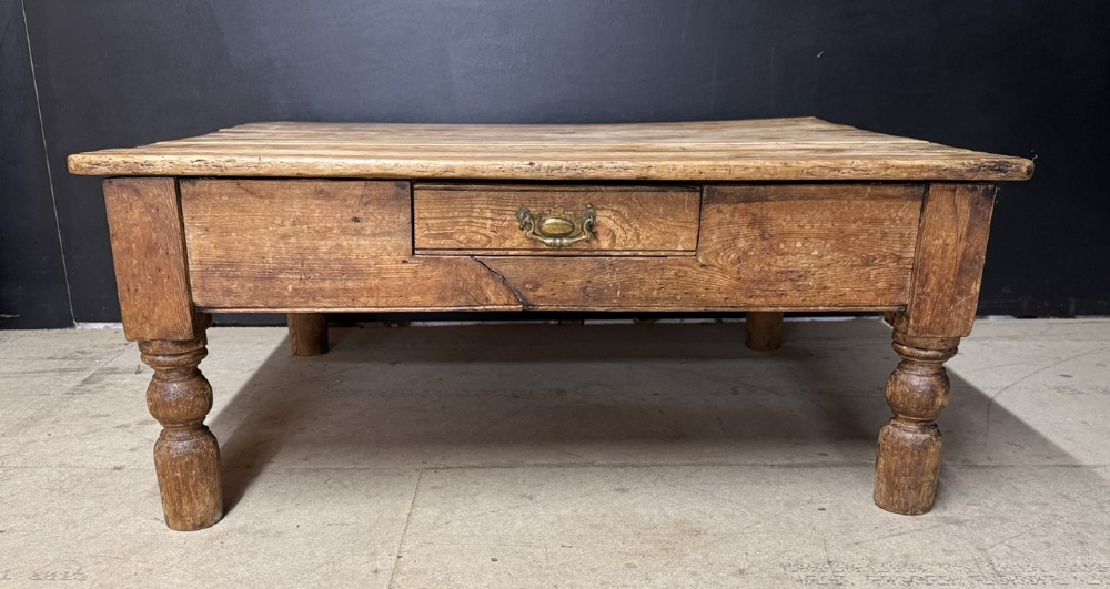 A low rectangular rustic pine coffee table featuring a plank top, turned corner legs, and a single central drawer with a brass drop handle. View II