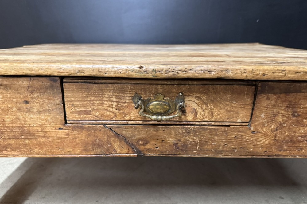 A low rectangular rustic pine coffee table featuring a plank top, turned corner legs, and a single central drawer with a brass drop handle. View III