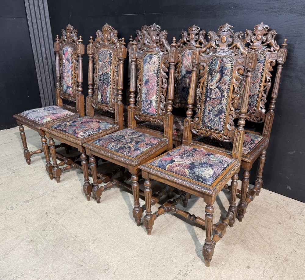 A set of eight high-backed dark oak dining chairs featuring carved lion crests and tapestry fabric upholstery. View III