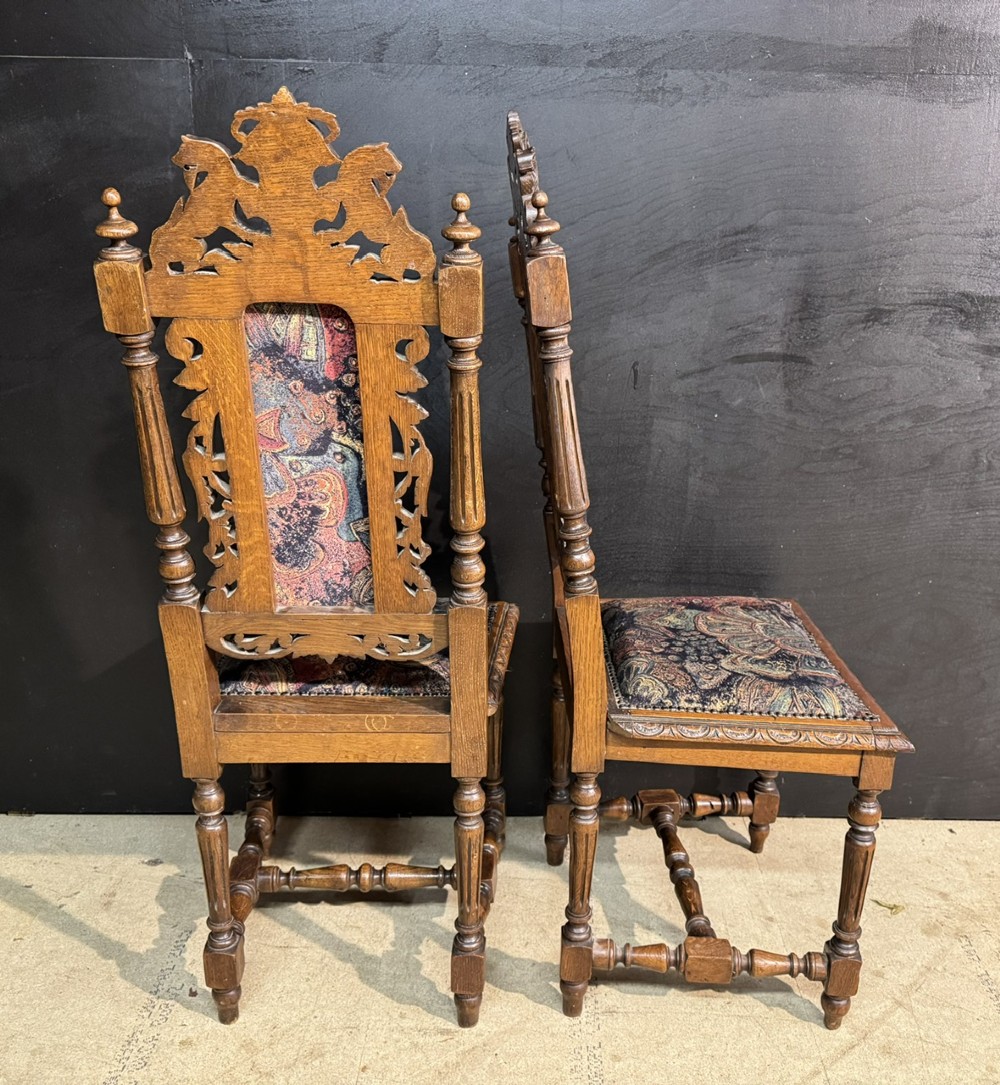 A set of eight high-backed dark oak dining chairs featuring carved lion crests and tapestry fabric upholstery. View VII