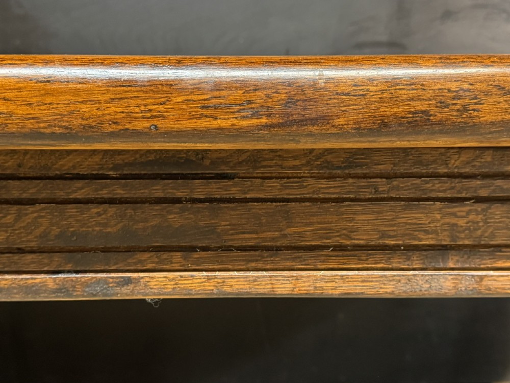 A long and deep solid dark oak farmhouse dining table featuring a plank top, moulded apron, and thick turned baluster legs joined by a floor-level stretcher. View XIII