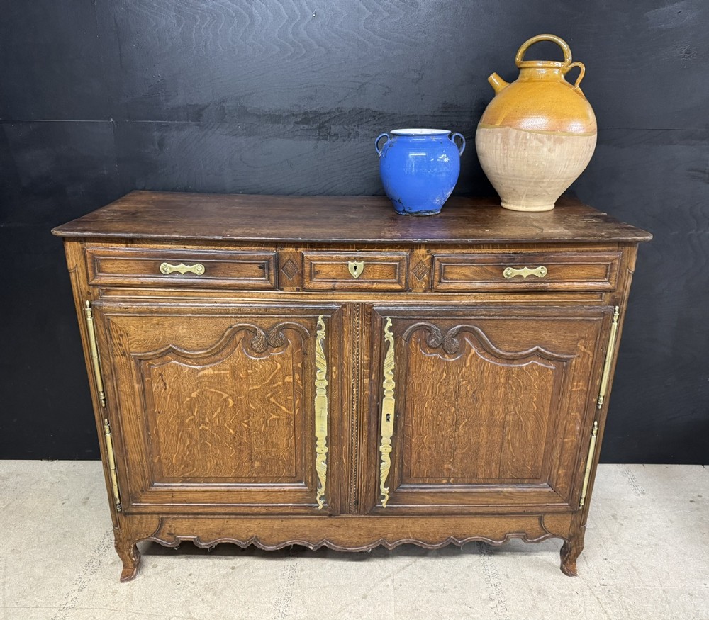 An 18th-century French provincial oak buffet featuring three top drawers above two carved panel doors with brass hardware. View II