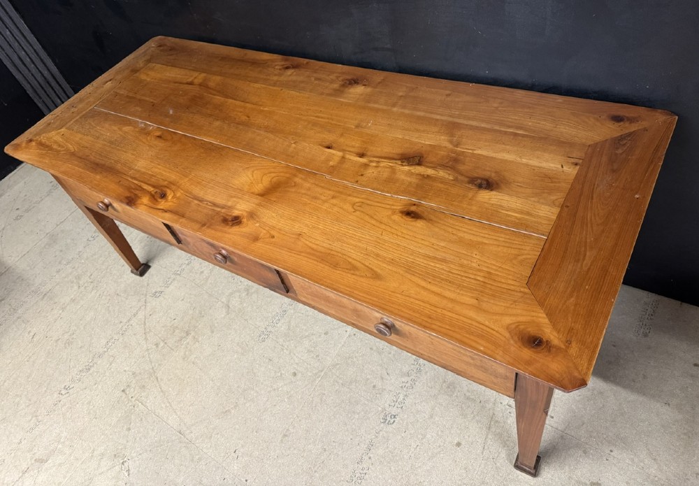 An 18th-century French provincial wooden console table featuring three frieze drawers with wooden turned knobs and four tapered square legs. View V