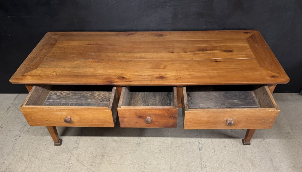 An 18th-century French provincial wooden console table featuring three frieze drawers with wooden turned knobs and four tapered square legs. View X
