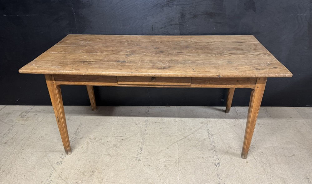 A rectangular natural oak French Normandy country table featuring a simple plank top, tapered legs, and a single frieze drawer. View II