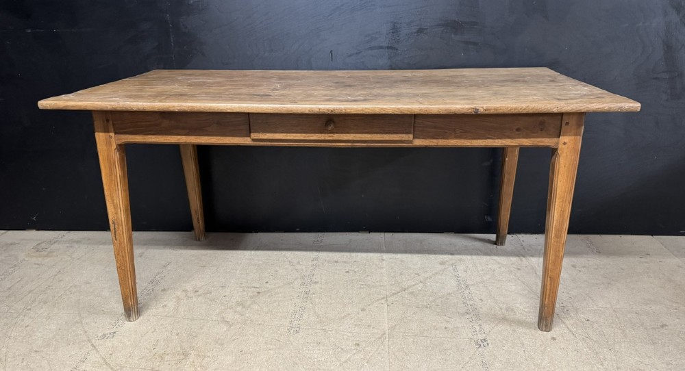 A rectangular natural oak French Normandy country table featuring a simple plank top, tapered legs, and a single frieze drawer. View III