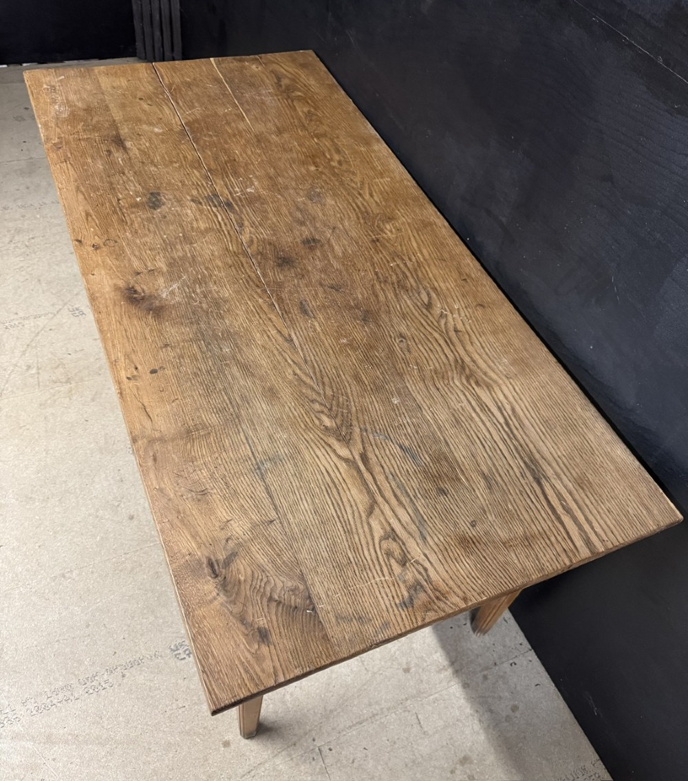 A rectangular natural oak French Normandy country table featuring a simple plank top, tapered legs, and a single frieze drawer. View IV