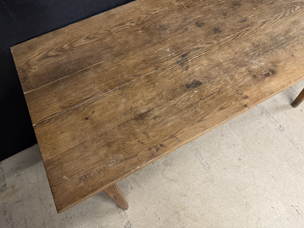 A rectangular natural oak French Normandy country table featuring a simple plank top, tapered legs, and a single frieze drawer. View VI