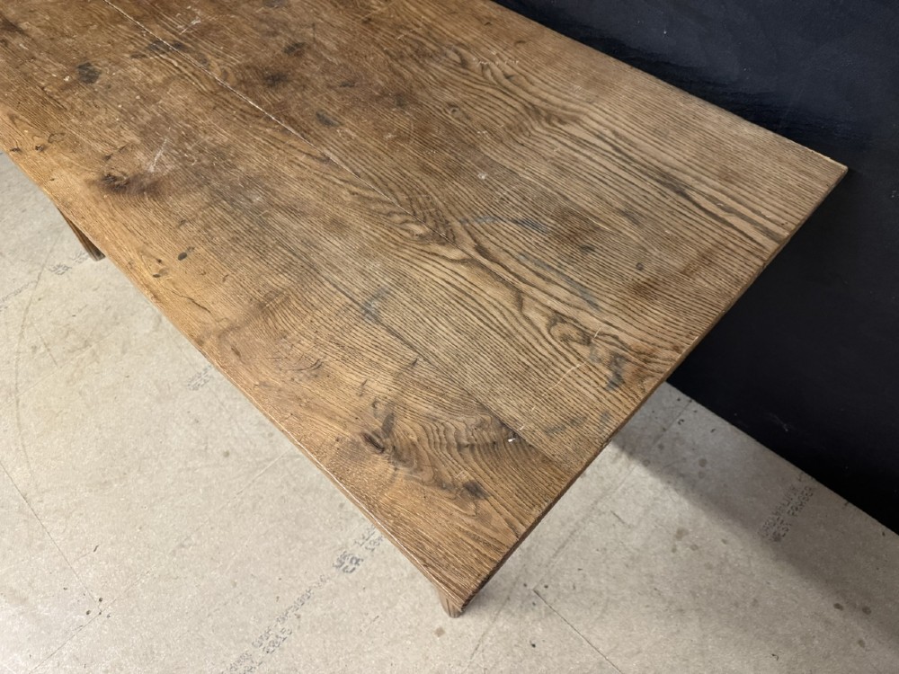 A rectangular natural oak French Normandy country table featuring a simple plank top, tapered legs, and a single frieze drawer. View VII